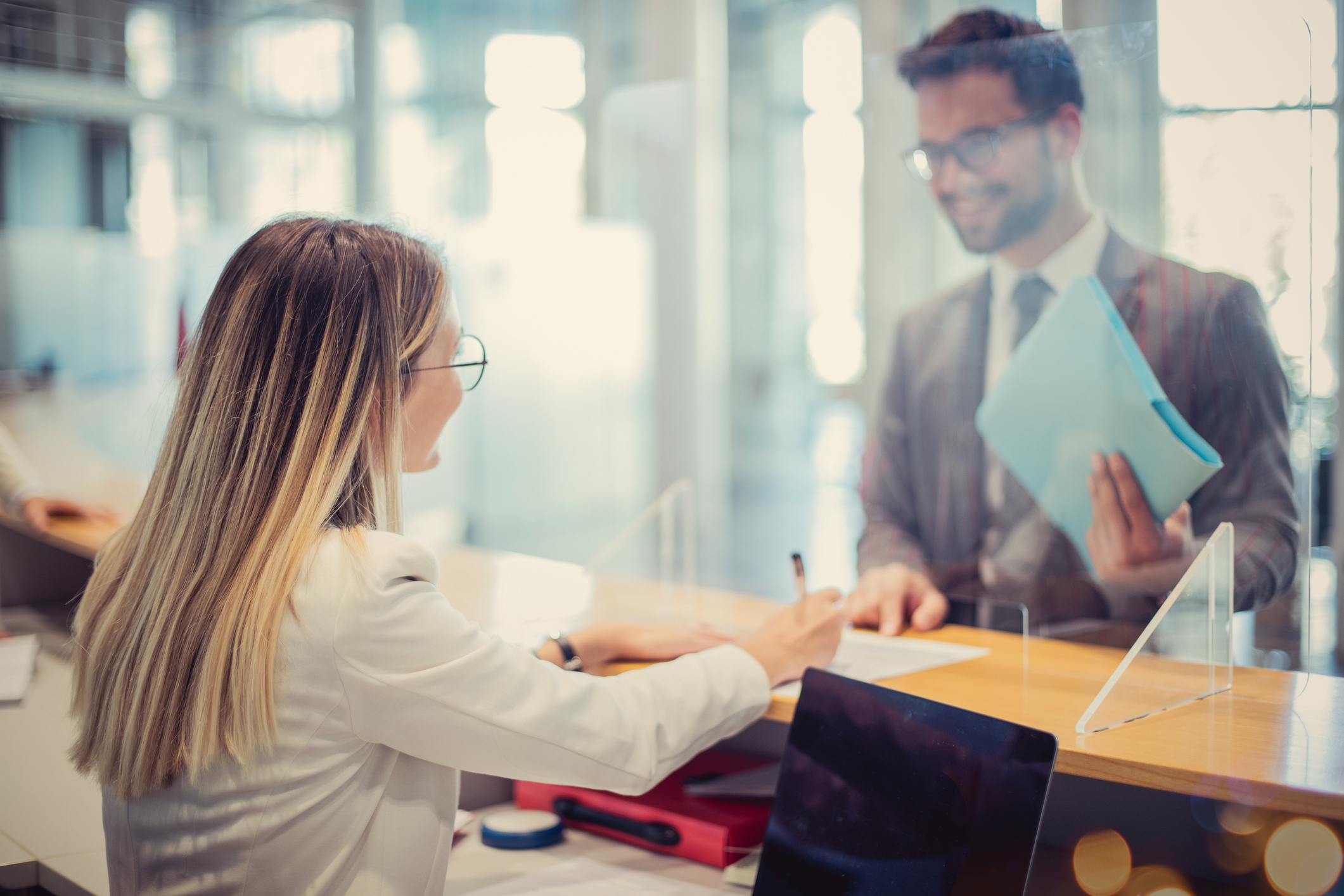 Woman helping man at bank